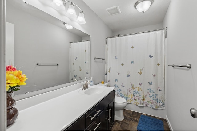 bathroom featuring tile flooring, large vanity, toilet, and a textured ceiling