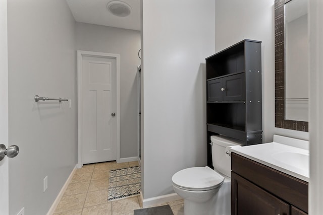 bathroom with tile floors, toilet, and vanity