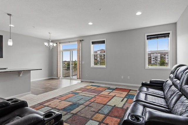 living room with plenty of natural light, wood-type flooring, and a chandelier