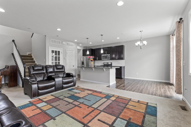 living room featuring light carpet and a chandelier