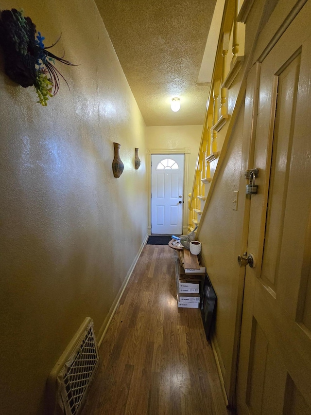 entryway featuring a textured ceiling and dark wood-type flooring