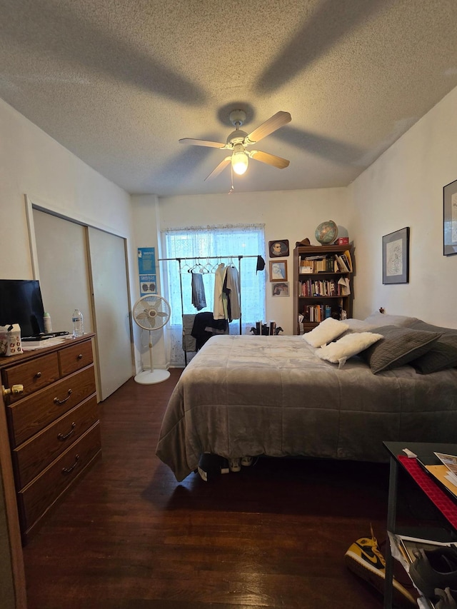 bedroom featuring a closet, ceiling fan, dark hardwood / wood-style flooring, and a textured ceiling