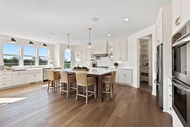 kitchen with a breakfast bar area, white cabinetry, a kitchen island, and stainless steel appliances