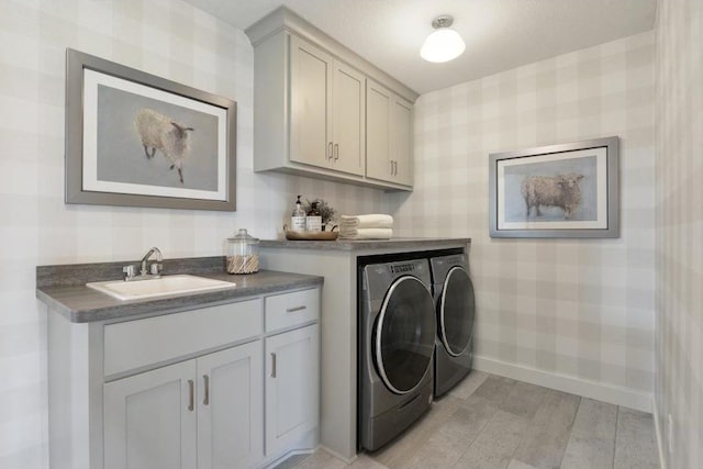 laundry area featuring washer and clothes dryer, cabinets, and sink