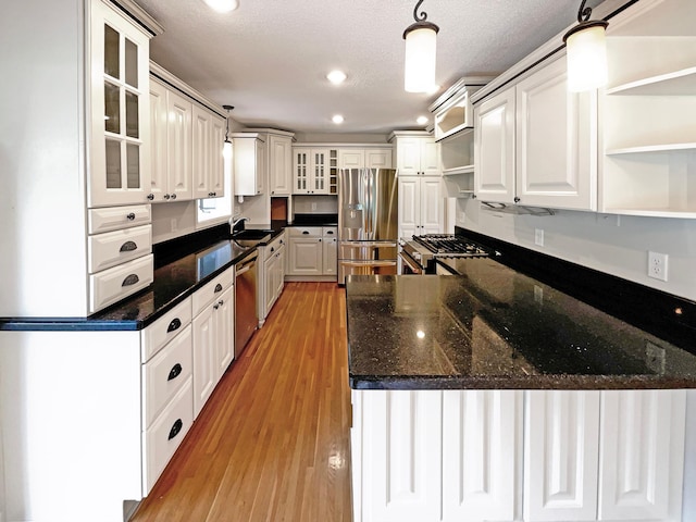 kitchen with open shelves, appliances with stainless steel finishes, hanging light fixtures, and white cabinetry