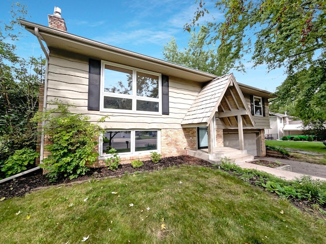 view of front of house featuring concrete driveway, a chimney, an attached garage, a front lawn, and brick siding