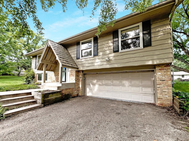 view of front of property featuring driveway, brick siding, and an attached garage