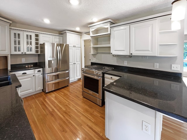 kitchen featuring light wood finished floors, glass insert cabinets, stainless steel appliances, white cabinetry, and open shelves