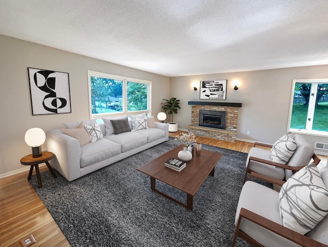 living area featuring a textured ceiling, a fireplace, and wood finished floors