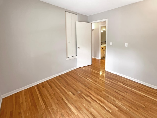 spare room with light wood-style floors and baseboards