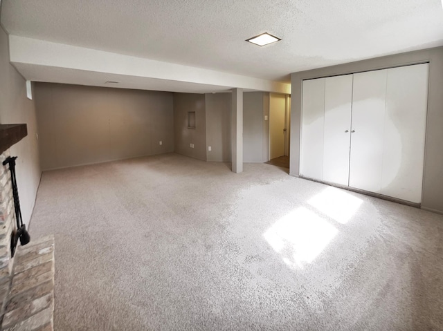 unfurnished bedroom with a brick fireplace, light carpet, and a textured ceiling