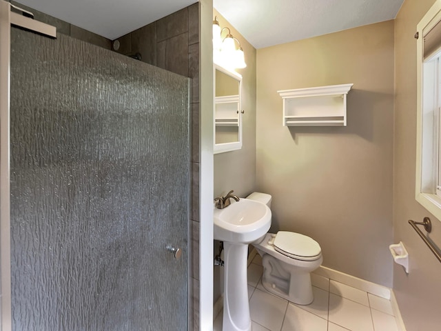 full bathroom featuring tile patterned flooring, toilet, baseboards, and walk in shower