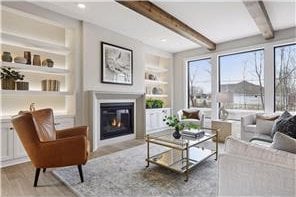 living room featuring hardwood / wood-style floors, beam ceiling, and built in features