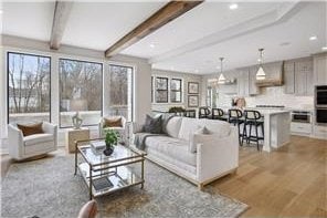 living room with light hardwood / wood-style flooring and beamed ceiling