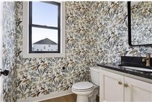 bathroom with hardwood / wood-style flooring, toilet, and vanity