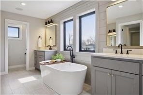 bathroom with tile flooring, a bathing tub, and vanity