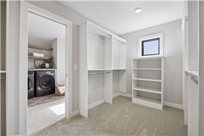 spacious closet with separate washer and dryer and light tile floors