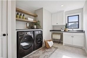 laundry area featuring cabinets, sink, and washer and dryer