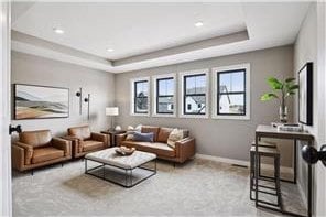 carpeted living room featuring a tray ceiling