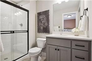 bathroom with vanity, toilet, and a shower with shower door