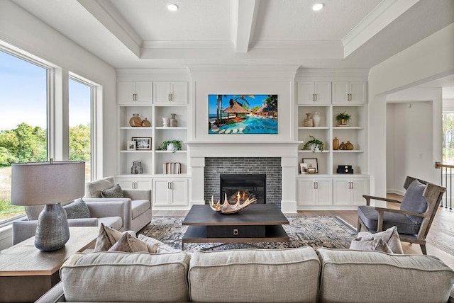 living room featuring beam ceiling, hardwood / wood-style flooring, and a tiled fireplace