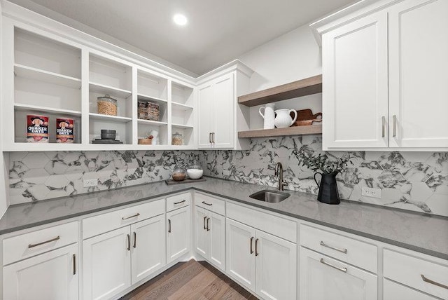 kitchen featuring white cabinets, tasteful backsplash, dark wood-type flooring, and sink