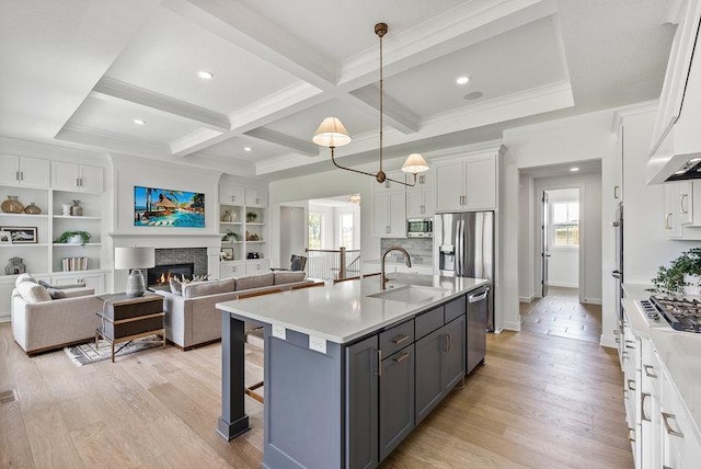 kitchen featuring white cabinets, light hardwood / wood-style flooring, an island with sink, and plenty of natural light