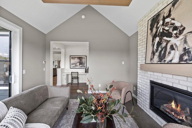 living room with brick wall, dark hardwood / wood-style flooring, vaulted ceiling, and a fireplace