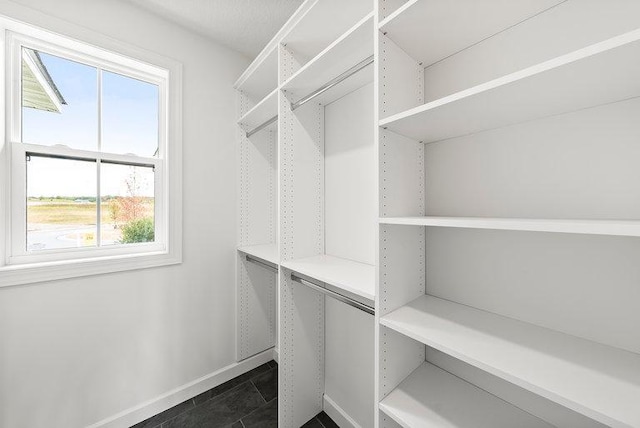 spacious closet featuring dark tile floors