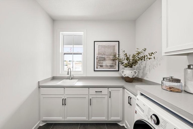 laundry room featuring cabinets, sink, washer / clothes dryer, and dark tile floors