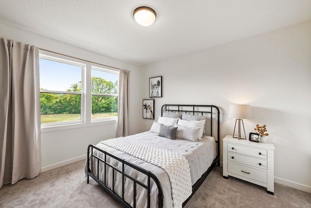 bedroom with light carpet and a textured ceiling