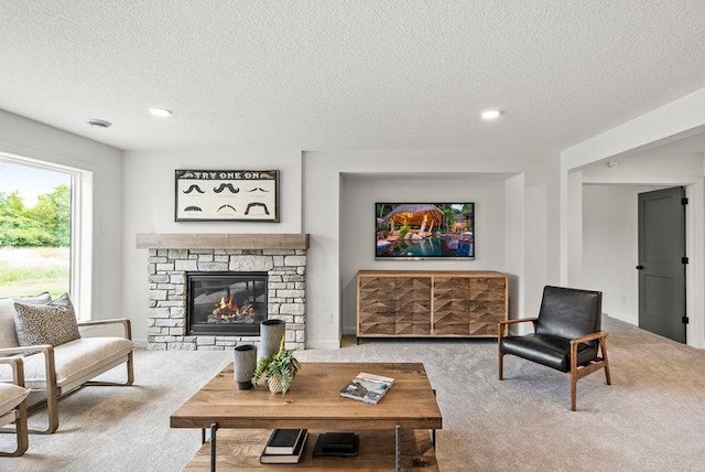 living room featuring a fireplace, a textured ceiling, and carpet flooring