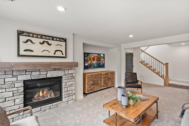 living room with a fireplace, carpet floors, and a textured ceiling