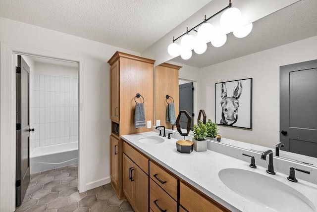 bathroom with vanity with extensive cabinet space, shower / tub combination, tile flooring, dual sinks, and a textured ceiling