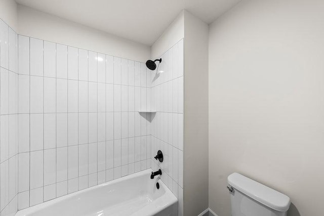 bathroom featuring tiled shower / bath combo and toilet