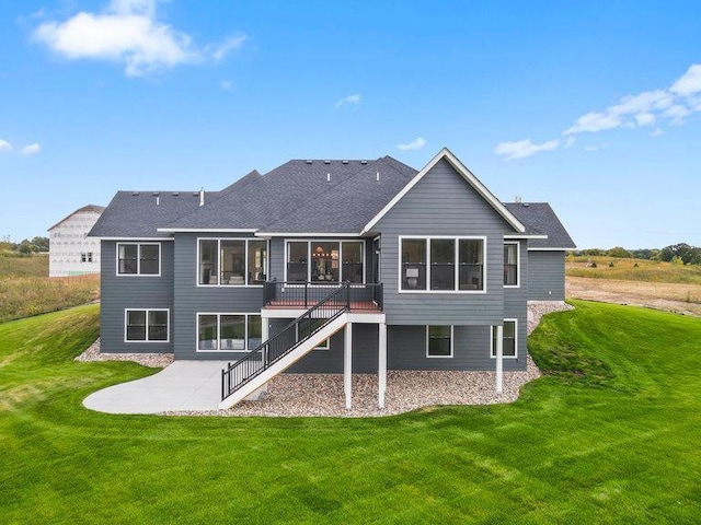 rear view of property featuring a lawn and a patio area