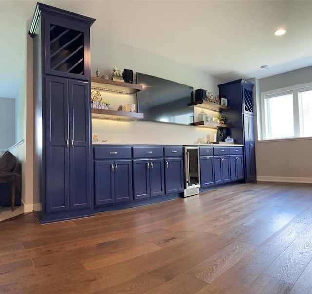 kitchen with blue cabinetry, wine cooler, and dark hardwood / wood-style floors