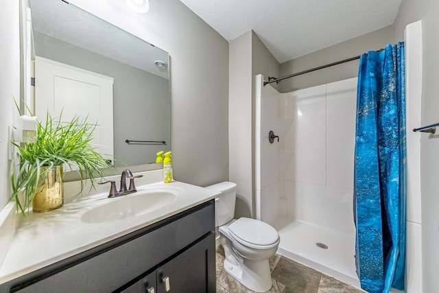 bathroom with a shower with curtain, a textured ceiling, vanity, and toilet