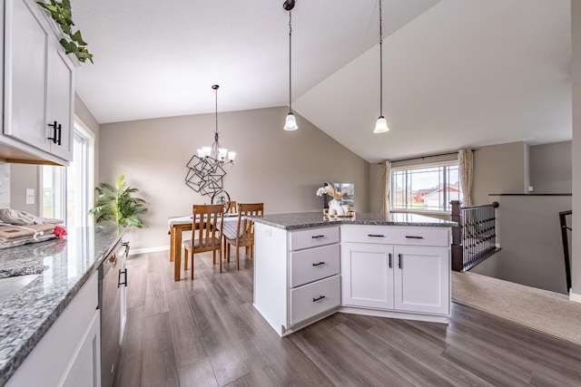 kitchen with pendant lighting, white cabinets, vaulted ceiling, and hardwood / wood-style floors