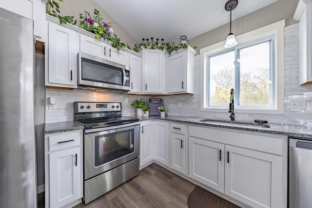 kitchen with white cabinetry, a textured ceiling, appliances with stainless steel finishes, and sink