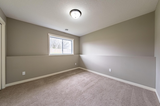 unfurnished room with carpet, vaulted ceiling, and a textured ceiling