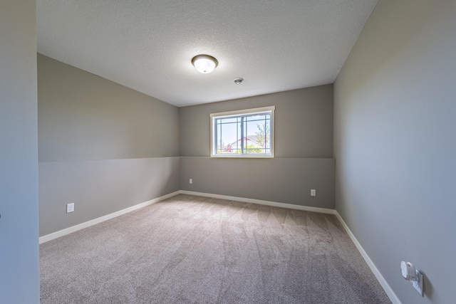 carpeted spare room with a textured ceiling and vaulted ceiling