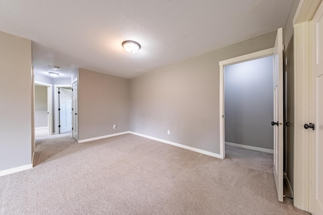 carpeted empty room with a textured ceiling