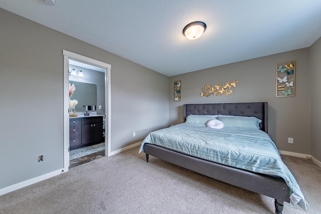 bedroom with a textured ceiling, carpet, and connected bathroom