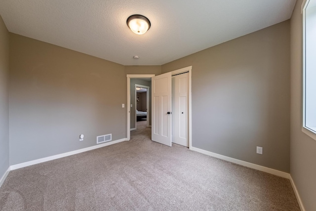 carpeted spare room featuring a textured ceiling