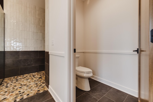 bathroom featuring tile patterned flooring, a shower, and toilet