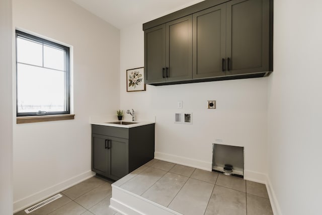 clothes washing area featuring sink, cabinets, washer hookup, electric dryer hookup, and light tile patterned flooring