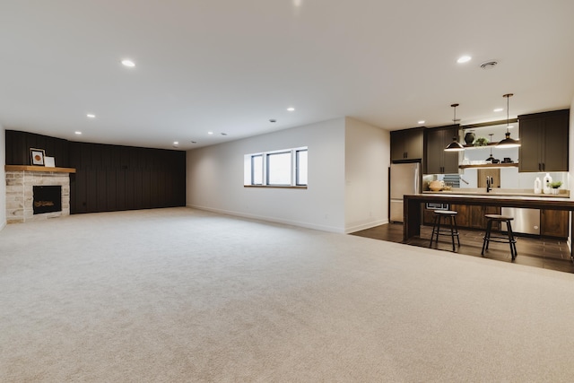 living room with sink, a fireplace, and dark colored carpet