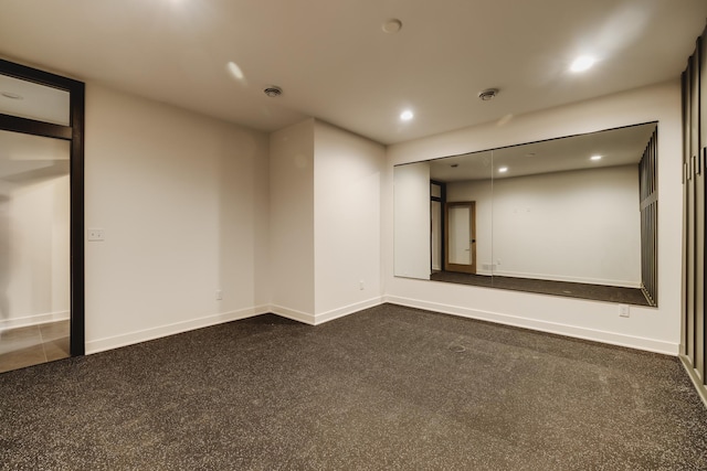 spare room featuring dark colored carpet