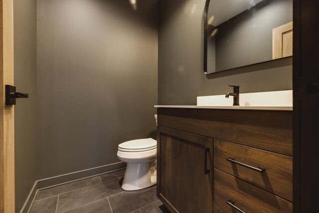 bathroom featuring tile patterned flooring, vanity, and toilet